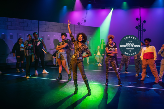 Actors fanned out across a stage during a musical at UNC School of the Arts.