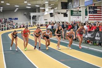 Competition runners toe the starting line on the indoor track at JDL Fast Track sports event center in Winston-Salem, North Carolina.