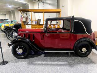 An old, red restored vintage car sits at the Kernersville Auto Museum on display.