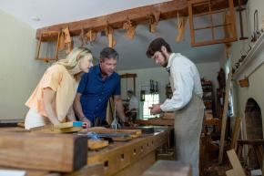 A man and woman take part in a hands-on trade demonstration at the woodworking house at Old Salem Museums and Gardens in Winston-Salem, North Carolina.