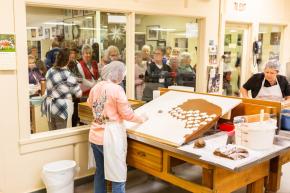 A group tour at Mrs. Hanes Cookie Factory stops to admire the work of employees hand cutting their famous Moravian cookies.