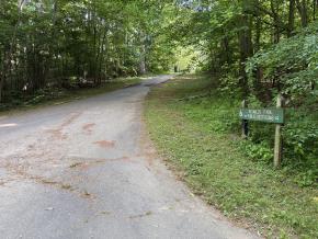A small wooden sign marks the entrance to Reynolds Park, connected to the Salem Creek Greenway Trail.