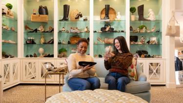 Two women admire shoes inside of Monkees of the Village Boutique in Reynolda Village Shopping Center.
